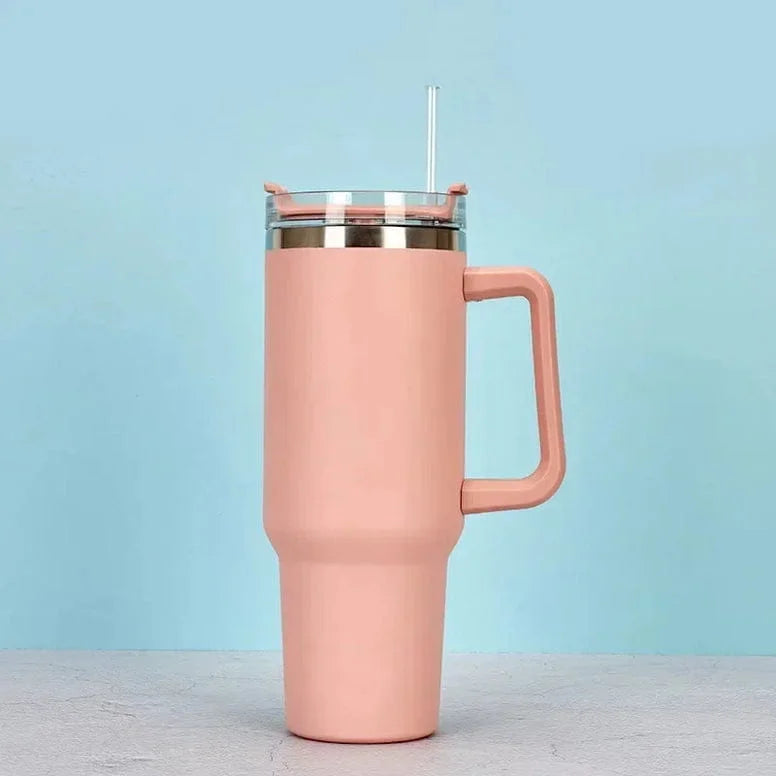 Pink insulated tumbler with a handle on a light blue background