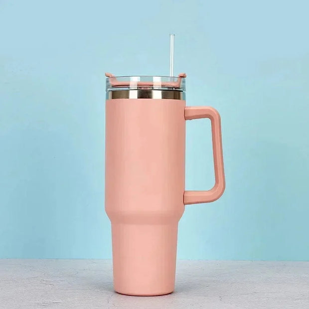 Pink insulated tumbler with a handle on a light blue background