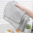 Person holding a gray mesh cleaning cloth with a white background