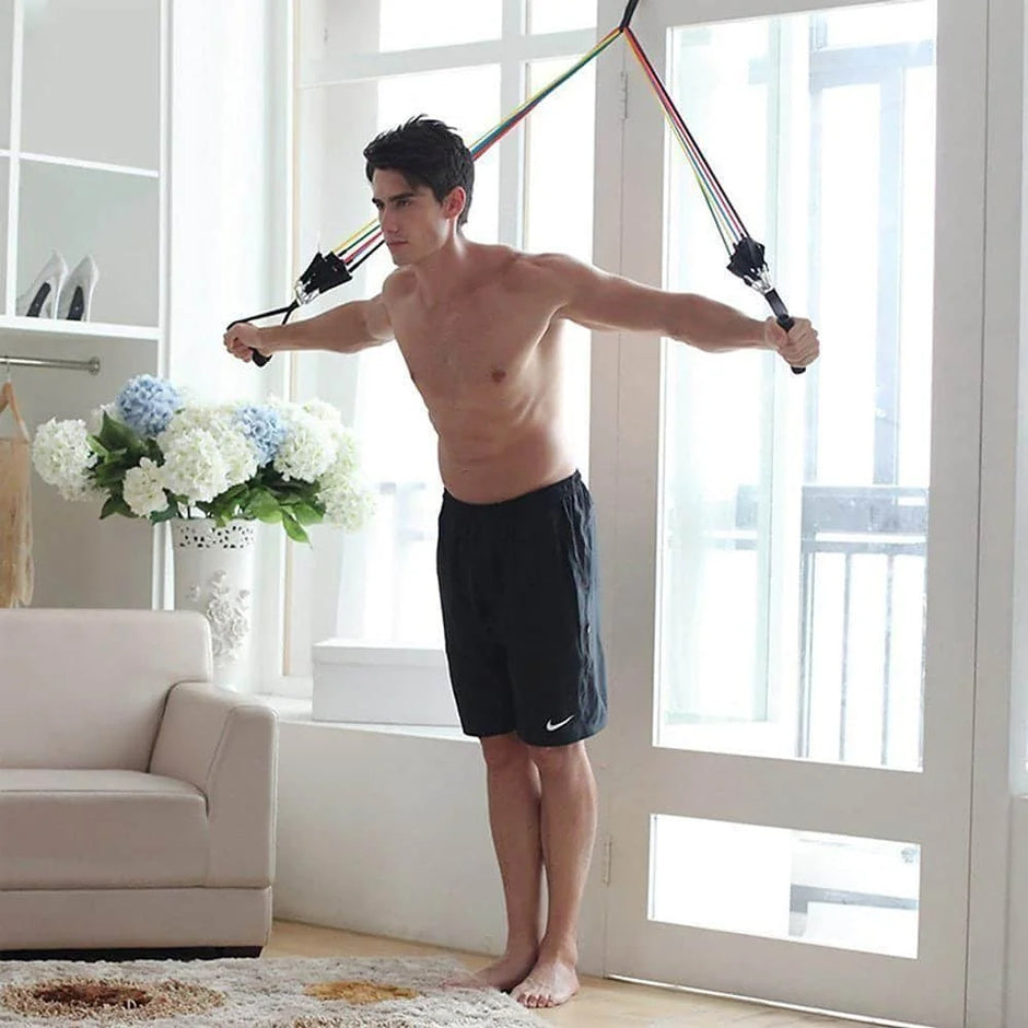 Man exercising with resistance bands in a bright living room.