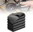 Stack of gray cleaning cloths with a hand using one on a kitchen stove.