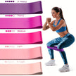 Woman exercising with resistance bands of different colors and strengths on a white background