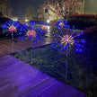 Decorative outdoor lights resembling fireworks on a wooden deck at night.