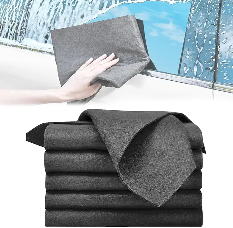 Gray microfiber cloth being used to clean a window with additional cloths stacked below.