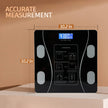 Black digital body fat scale with measurements on a beige background