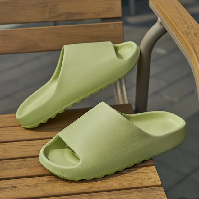Pair of green slides on a wooden surface with a blurred outdoor background