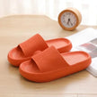 Orange slippers on a wooden surface with a clock in the background
