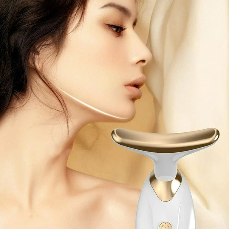 Woman using a gold and white skincare tool on her neck with a soft beige background