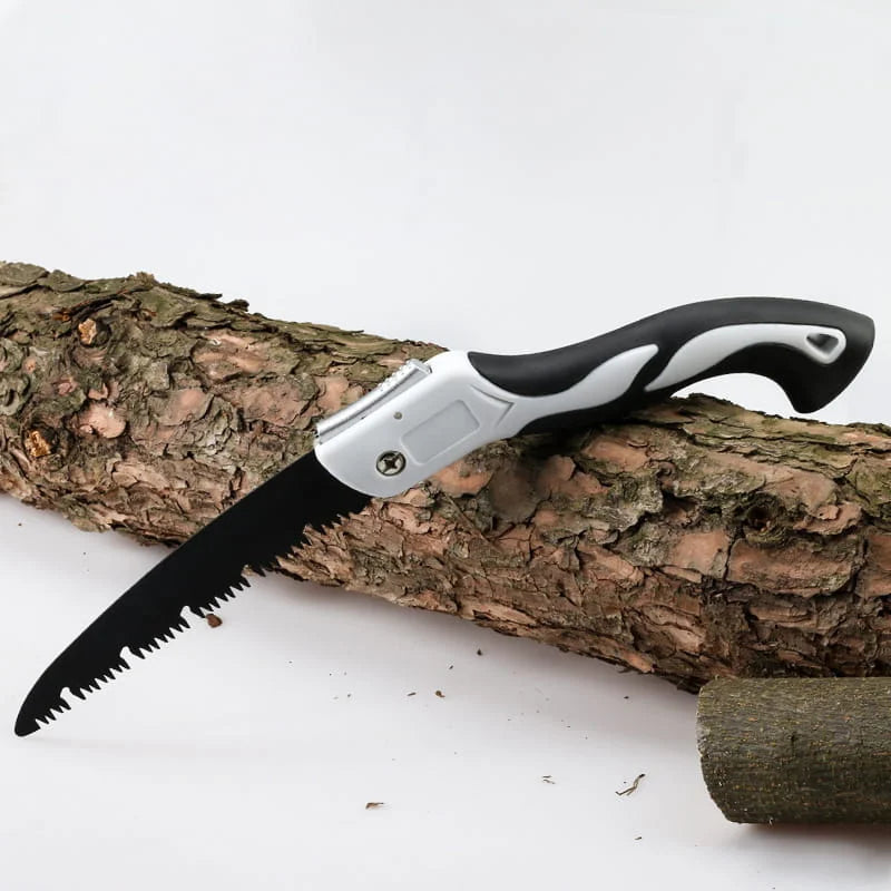 Folding saw with black and gray handle on a wooden log against a white background