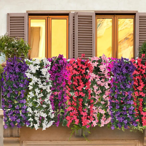 Artificial flower arrangements in purple, white, and pink hanging on a wall.
