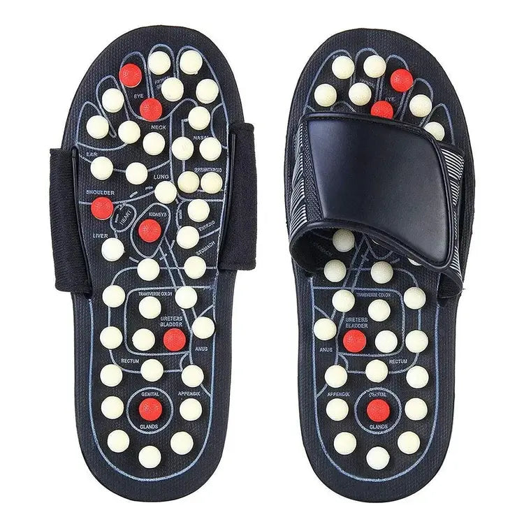 Pair of black acupressure sandals with white and red nodes on a white background