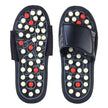 Pair of black acupressure sandals with white and red nodes on a white background
