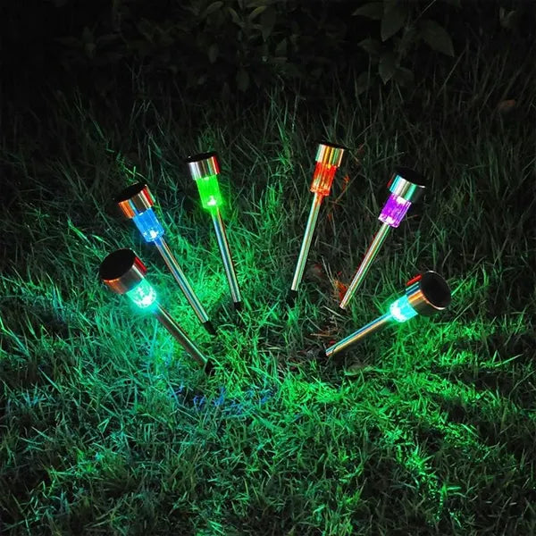 Colorful solar-powered garden lights on grass at night