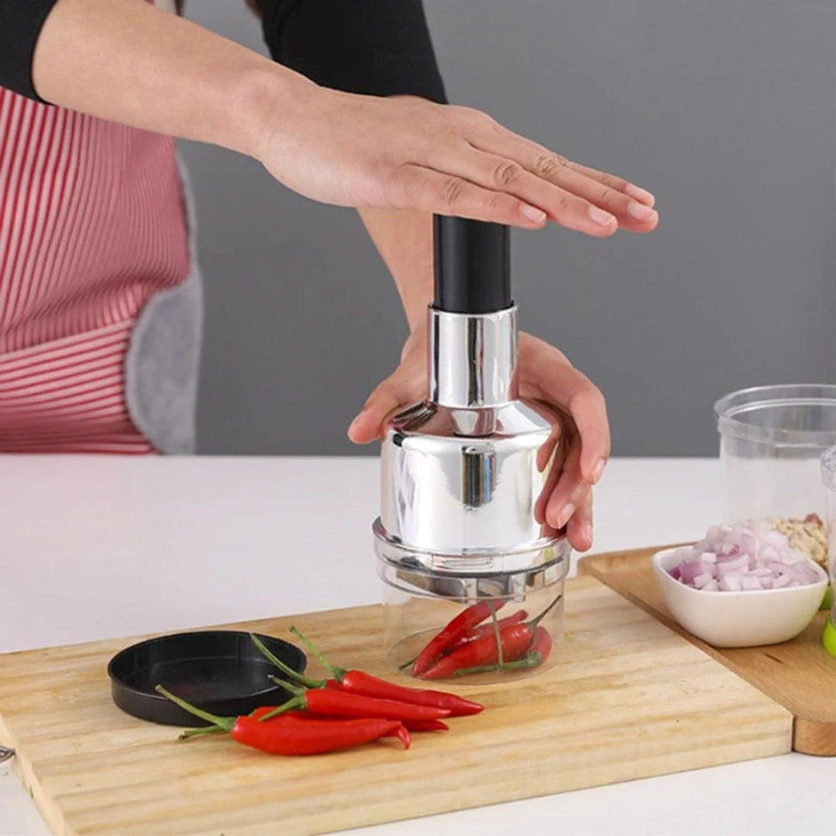 Person using a chili pepper grinder on a cutting board with red chilies