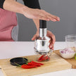 Person using a chili pepper grinder on a cutting board with red chilies
