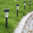Solar garden lights on grass next to a pathway